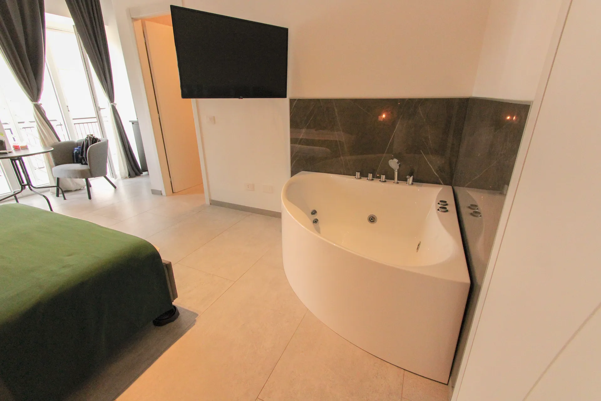 Vasca idromassaggio ad angolo Suite Urban Mood con vista zona living — boutique BnB Roma sud